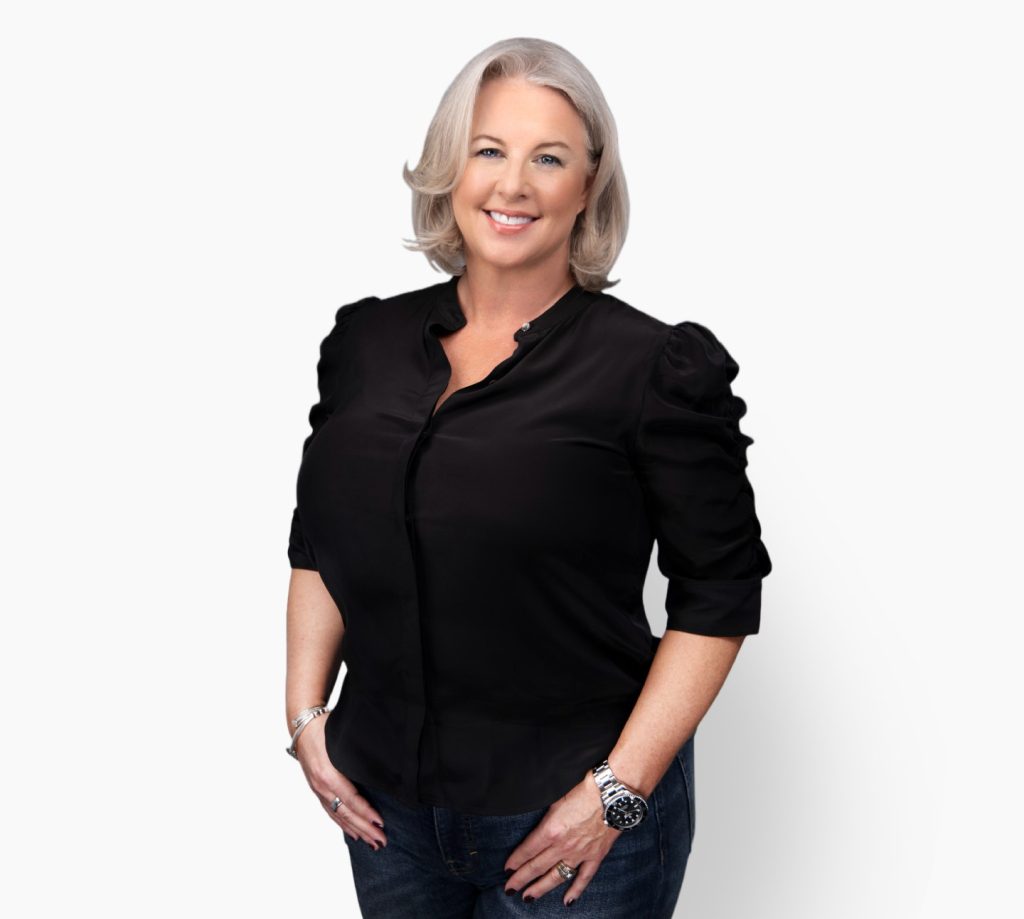 heather beardsley smiling, hands tucked in pockets, and wearing a stylish black top